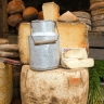 Pot à lait ancien et tomes de fromage