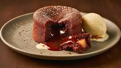 Mi-cuit au chocolat avec cœur coulant et morceaux de poire, servi tiède avec une boule de glace vanille fondante.