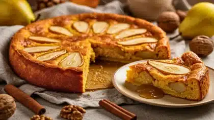 Clafoutis doré au potiron et aux poires, avec une part servie sur une assiette, montrant une texture fondante et fruitée.